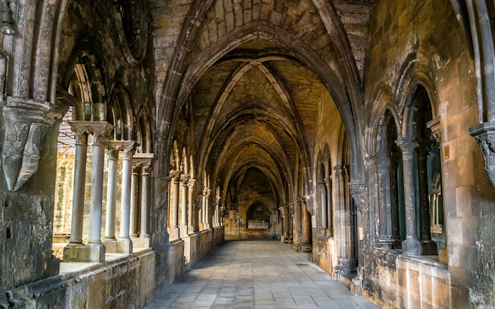 Cloisters of St Mary Major Cathedral in Lisbon with stone arches and columns.
