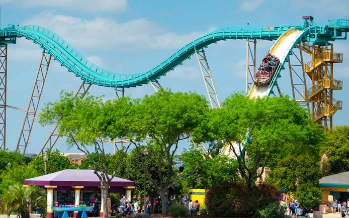 Atlantis ride at SeaWorld San Antonio with visitors on a steep descent.