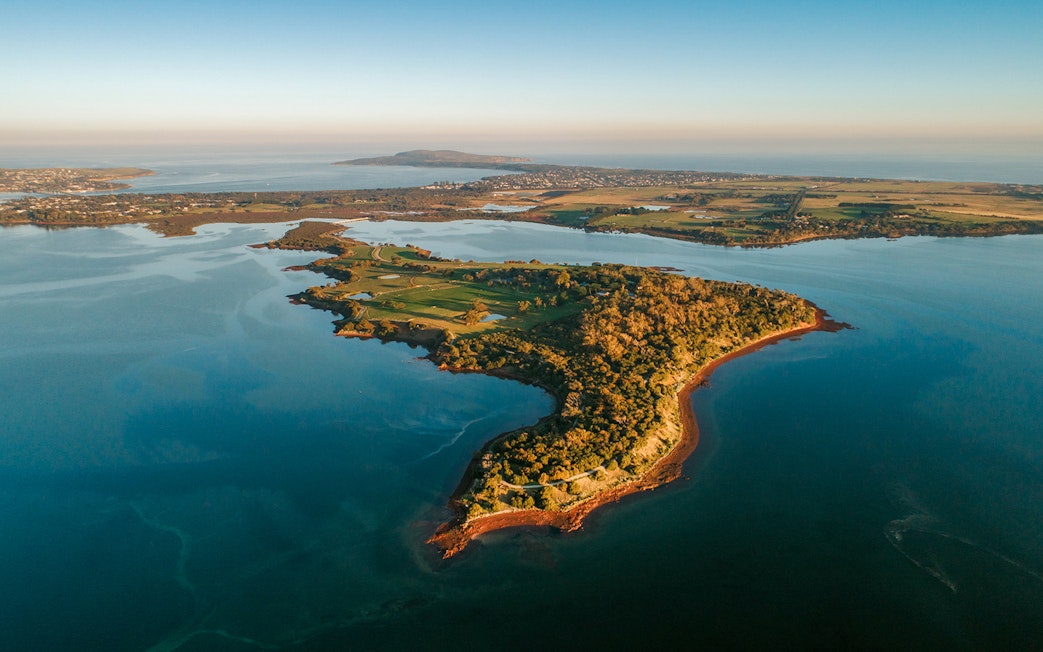Aerial view of Churchill Island surrounded by water and lush greenery.