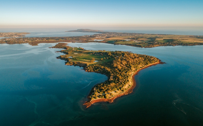Aerial view of Churchill Island surrounded by water and lush greenery.