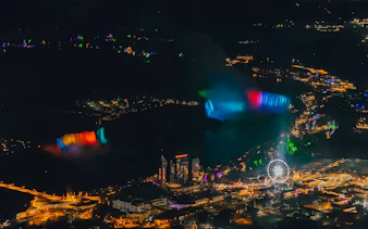 Niagara Falls illuminated at night during a winter helicopter flight, Canada.