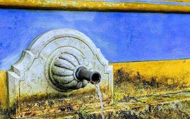 Stone fountain detail at Pena Palace, Sintra, with water flowing from a spout.