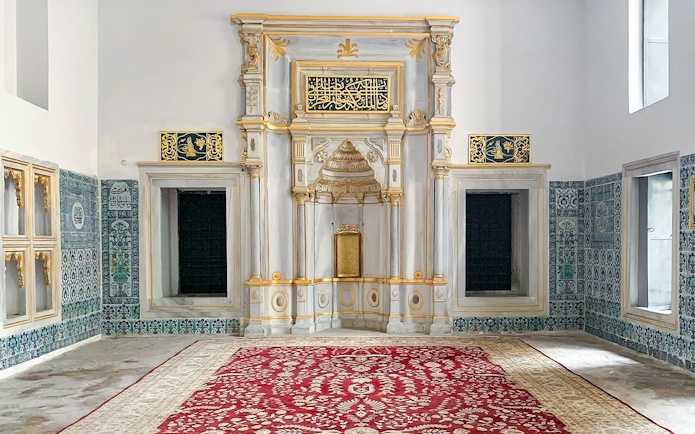 Topkapi Palace Museum interior with ornate wall tiles and decorative arch.
