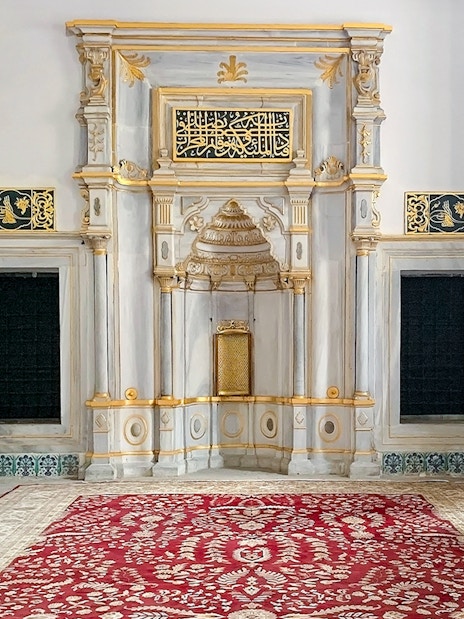 Topkapi Palace Museum interior with ornate wall tiles and decorative arch.