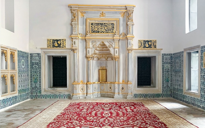 Topkapi Palace Museum interior with ornate wall tiles and decorative arch.
