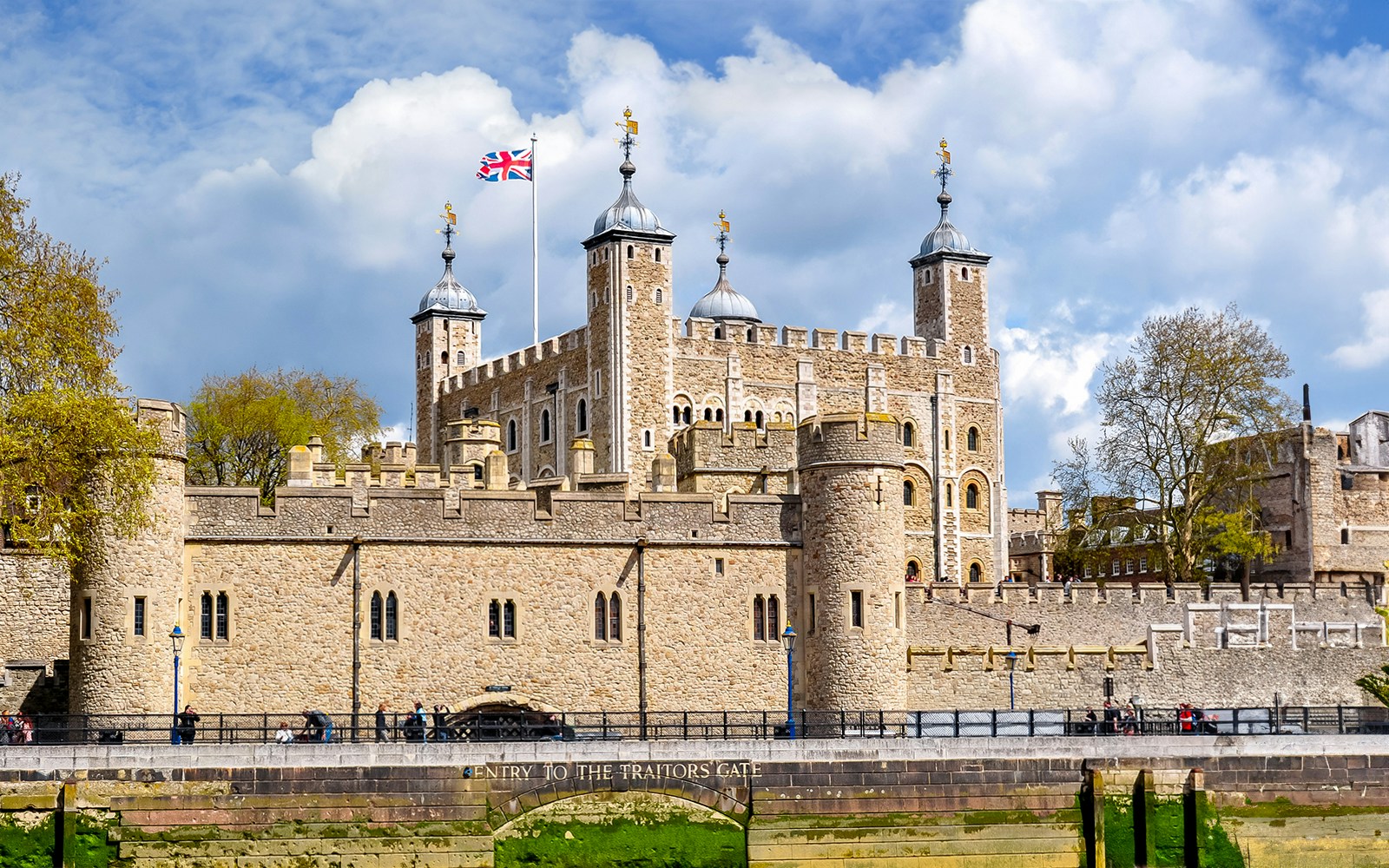 Tower of London with Union Jack flag, view of historic architecture in London.