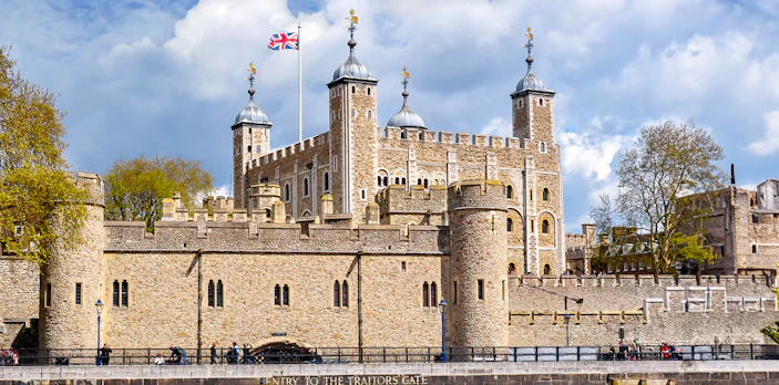 Tower of London with Union Jack flag, view of historic architecture in London.
