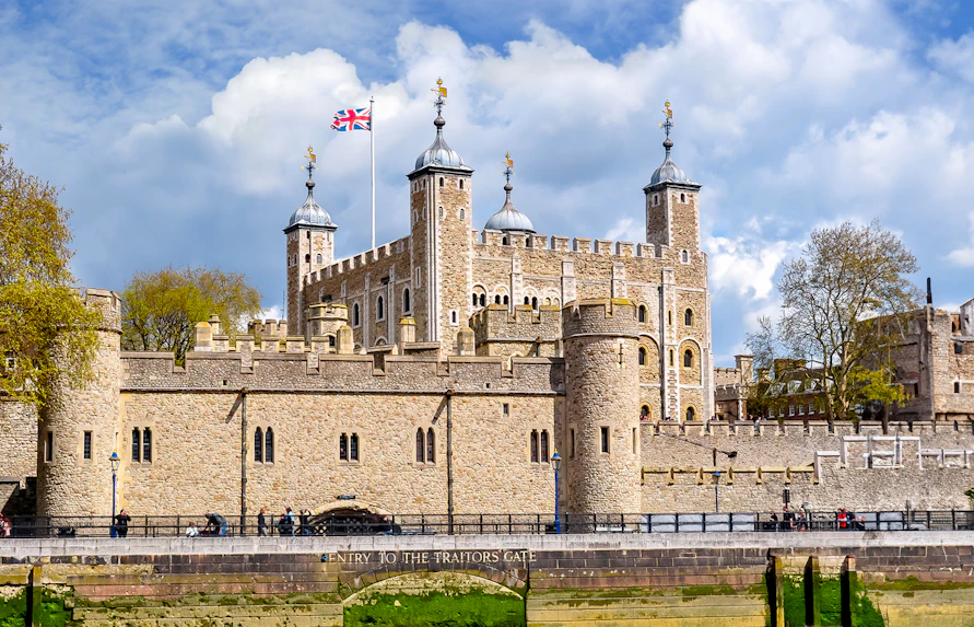 Tower of London with Union Jack flag, view of historic architecture in London.