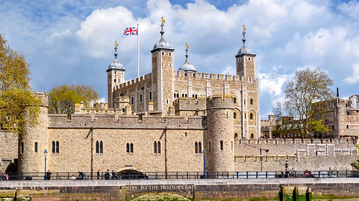 Tower of London with Union Jack flag, view of historic architecture in London.
