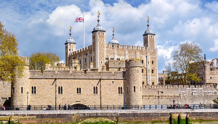 Tower of London with Union Jack flag, view of historic architecture in London.