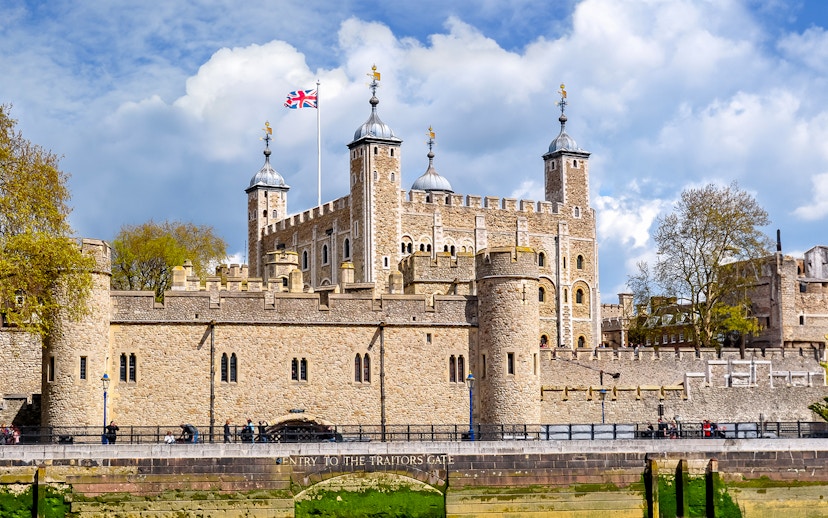 Tower of London with Union Jack flag, view of historic architecture in London.
