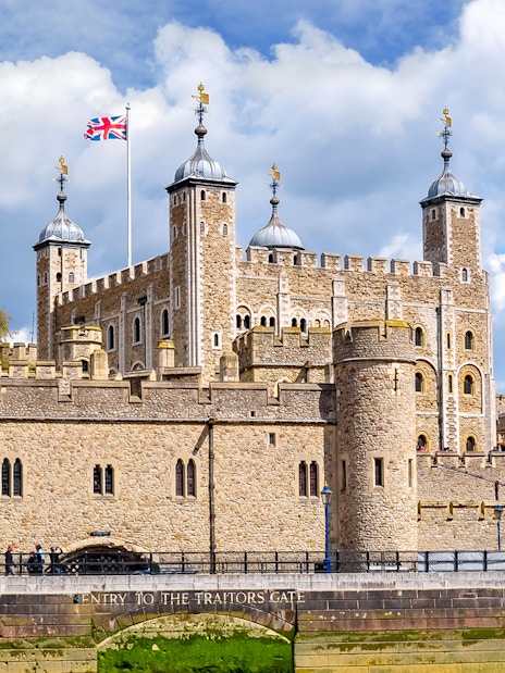 Tower of London with Union Jack flag, view of historic architecture in London.
