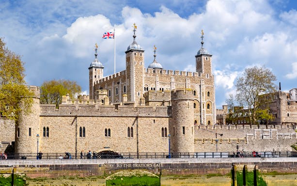 Tower of London with Union Jack flag, view of historic architecture in London.