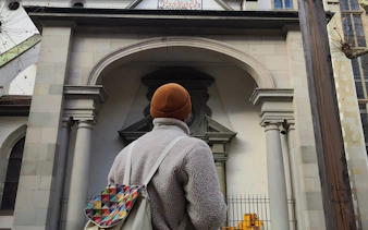 Person exploring historic building in Zürich during self-guided city game.
