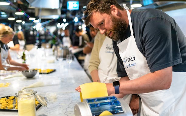 Participants making pasta in an Italian cooking class.