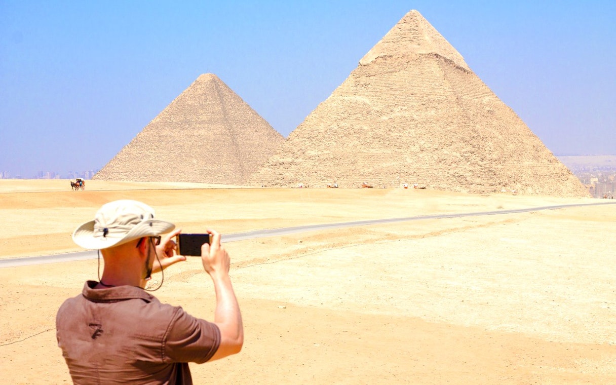 Tourist photographing the Pyramids of Giza in Egypt.