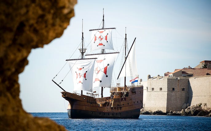 Historic ship sailing near Dubrovnik city walls on Panoramic Cruise and Walking Tour.
