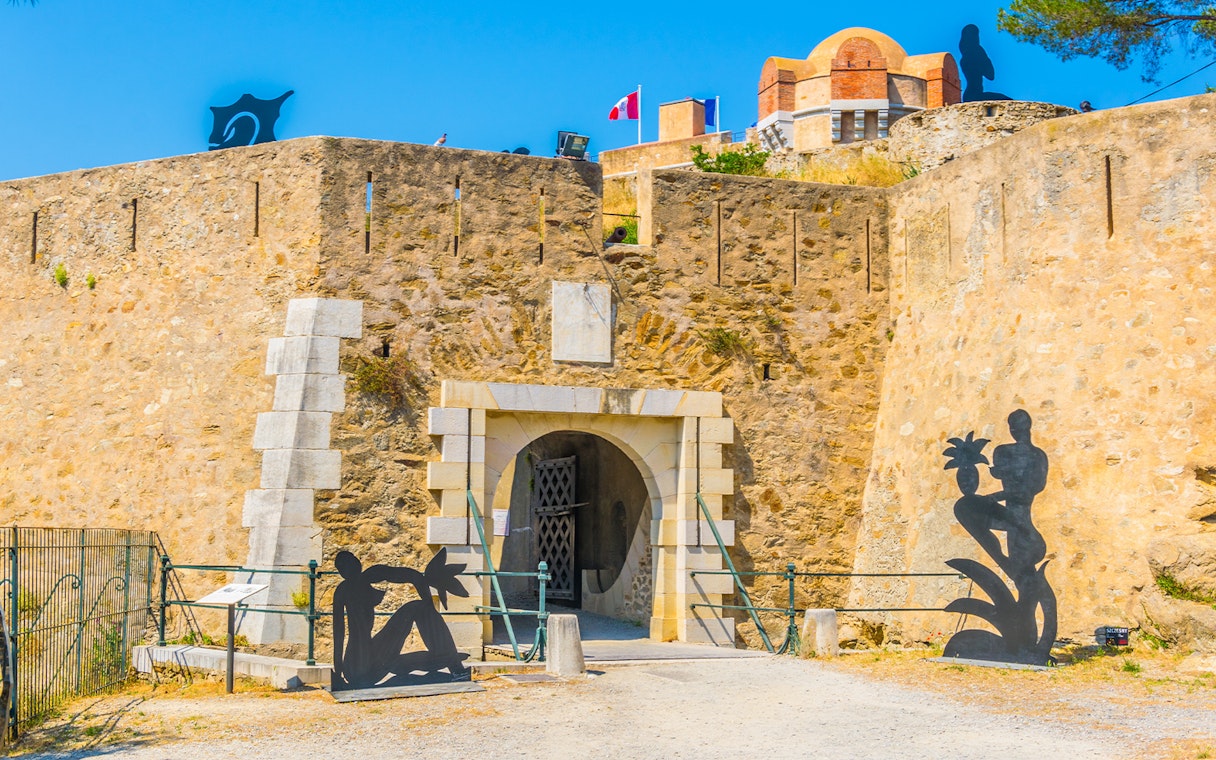 Entrance of the Citadel of Saint Tropez with sculptures and stone walls.