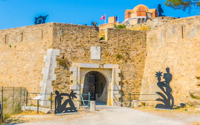 Entrance of the Citadel of Saint Tropez with sculptures and stone walls.
