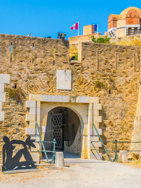 Entrance of the Citadel of Saint Tropez with sculptures and stone walls.