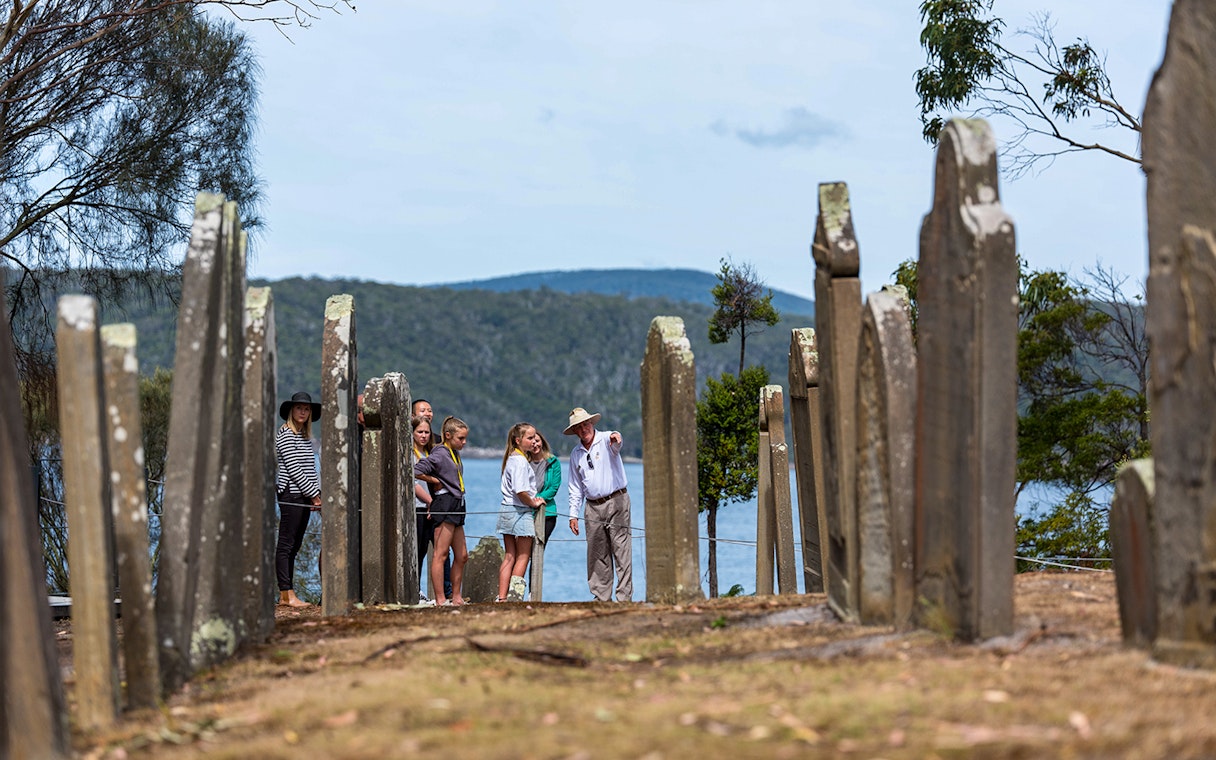 Tour group exploring gravestones at Port Arthur Historic Site, Isle of the Dead, Tasmania.