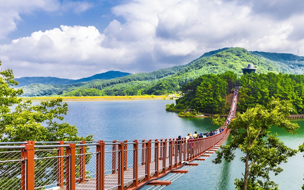 Lake Majang Suspension Bridge at Korean DMZ with visitors crossing over water.