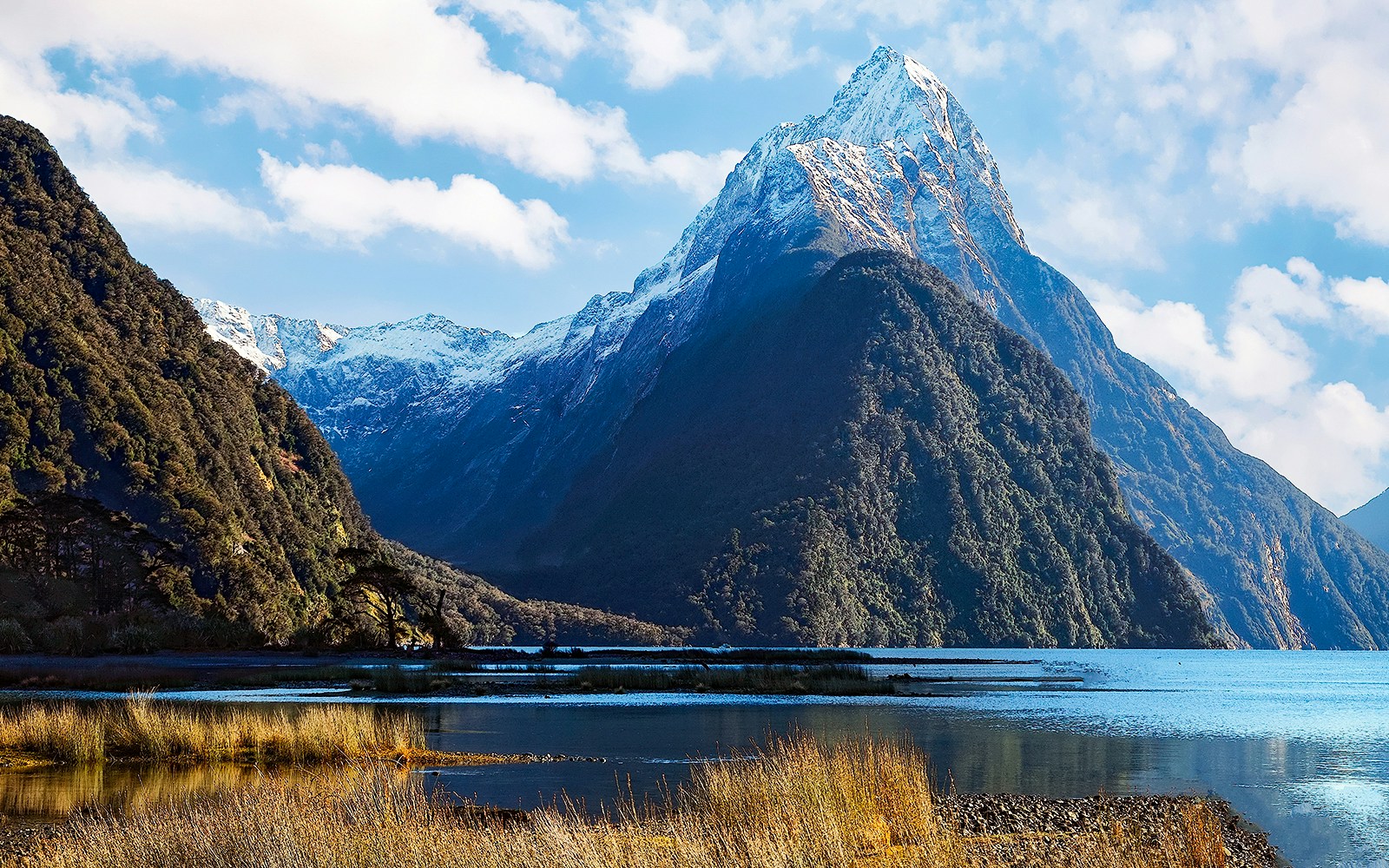 Mitre Peak towering over Milford Sound with reflective waters and lush greenery.