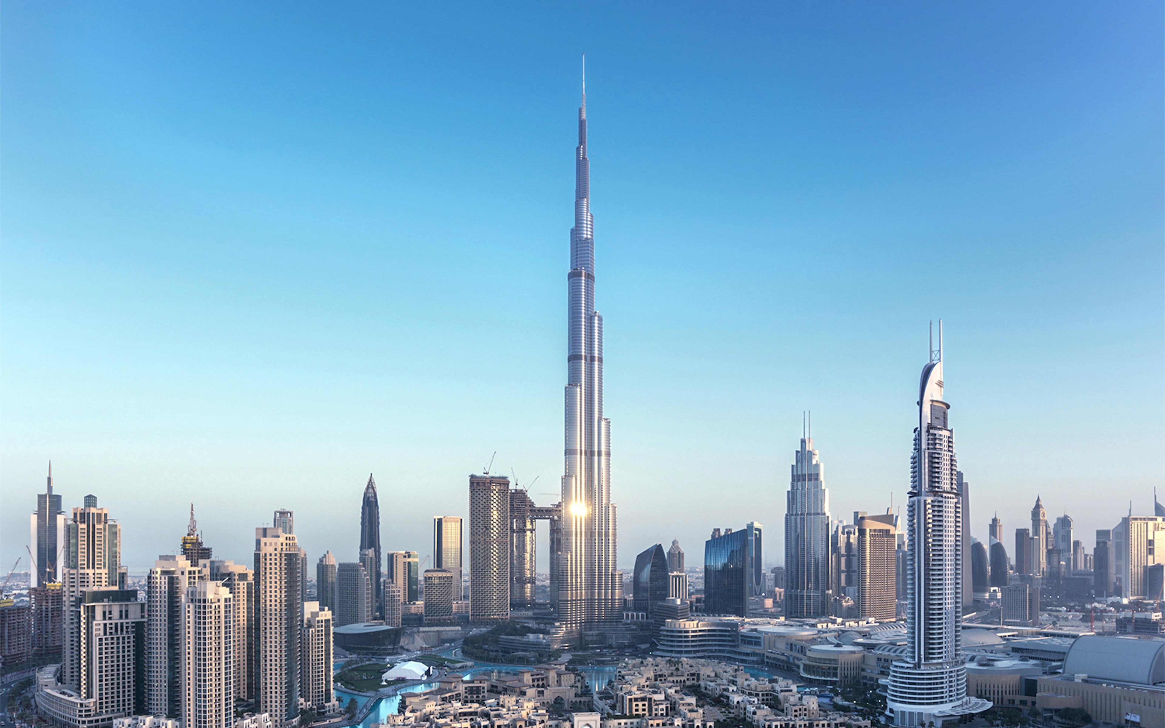 Burj Khalifa towering over Dubai skyline with surrounding skyscrapers.