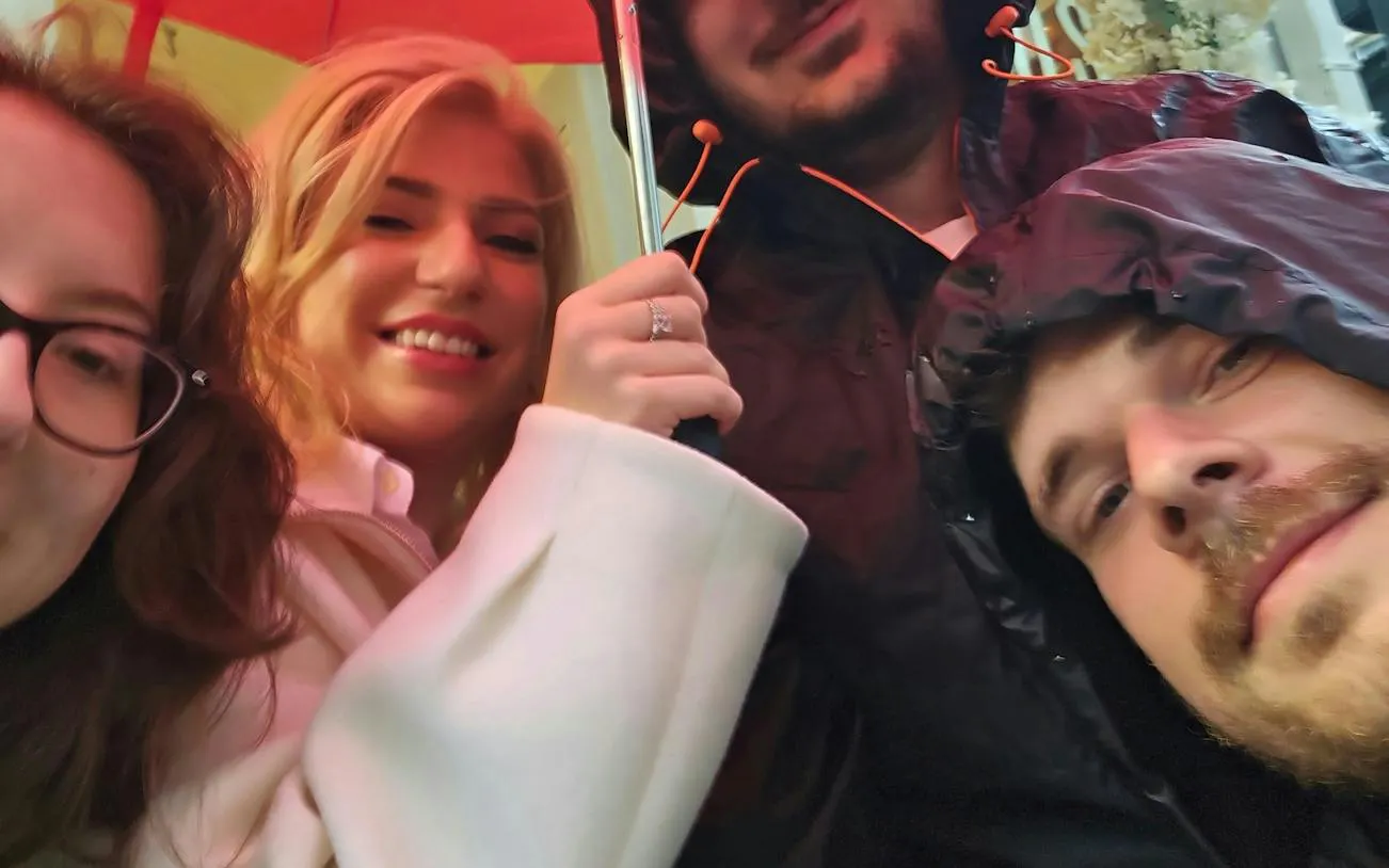 Group of people under an umbrella during the Brussels Detective X Rescue city game.