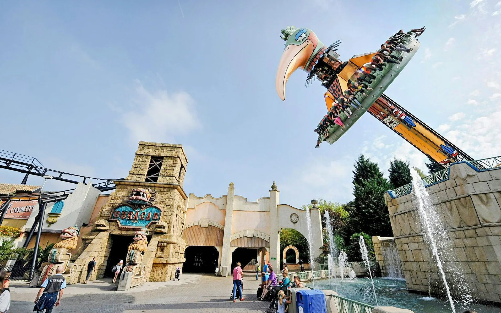 Thrill ride and entrance at Bellewaerde Park, Belgium with fountains and visitors.