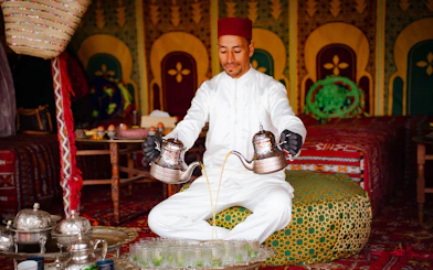 Man pouring tea during hot air balloon tour in Marrakech.