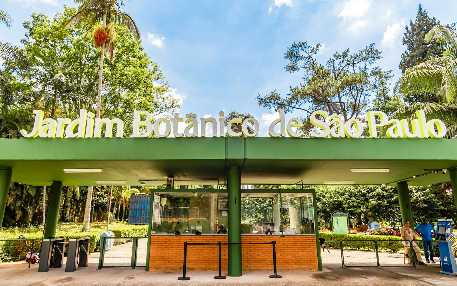 Entrance of Jardim Botânico de São Paulo with greenery and ticket booth.