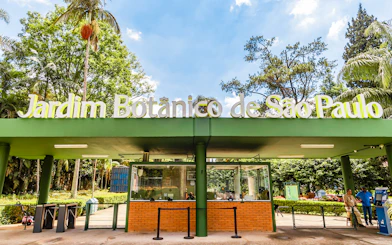 Entrance of Jardim Botânico de São Paulo with greenery and ticket booth.
