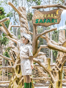Child in safari outfit at Vinpearl Safari entrance sign.