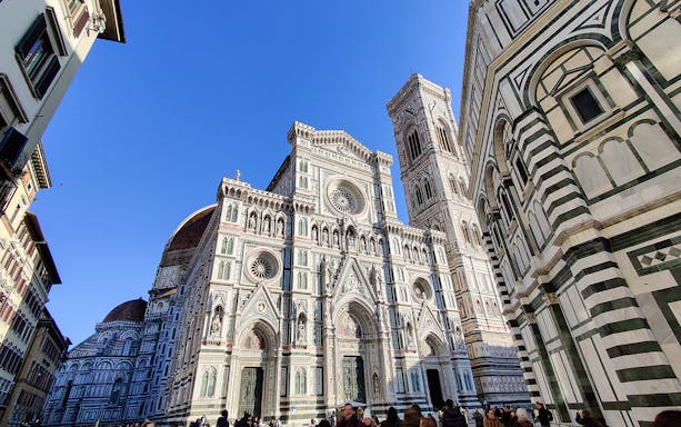 Florence Cathedral facade with Giotto's Campanile under clear sky, part of guided tour.