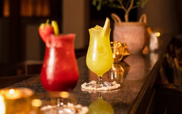 Colorful cocktails on a bar at Al Hadheerah Restaurant, Bab Al Shams desert resort.