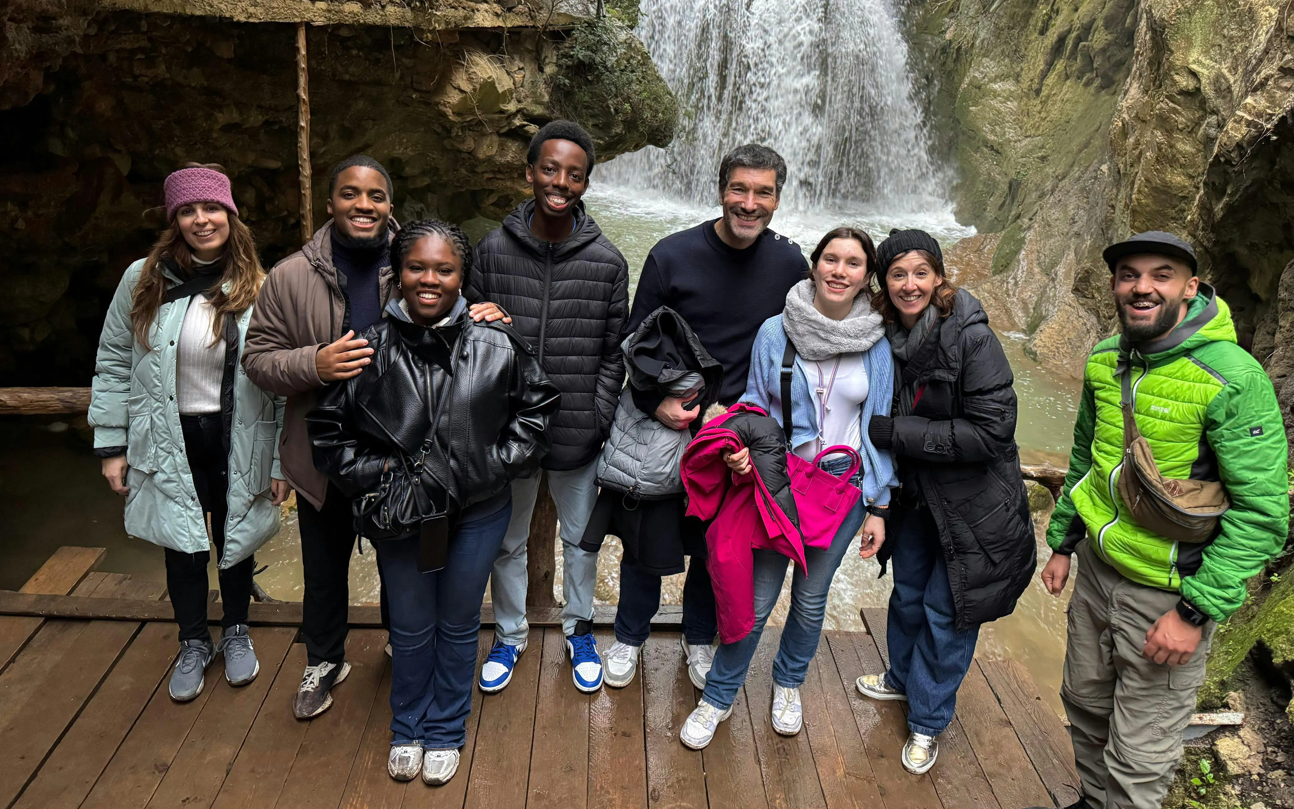 Tourists gathered on a wooden platform near Akchour Waterfalls in Morocco.