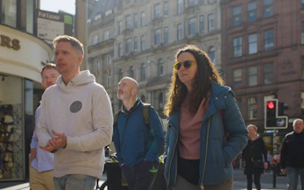 Group exploring Glasgow city streets on a walking tour.