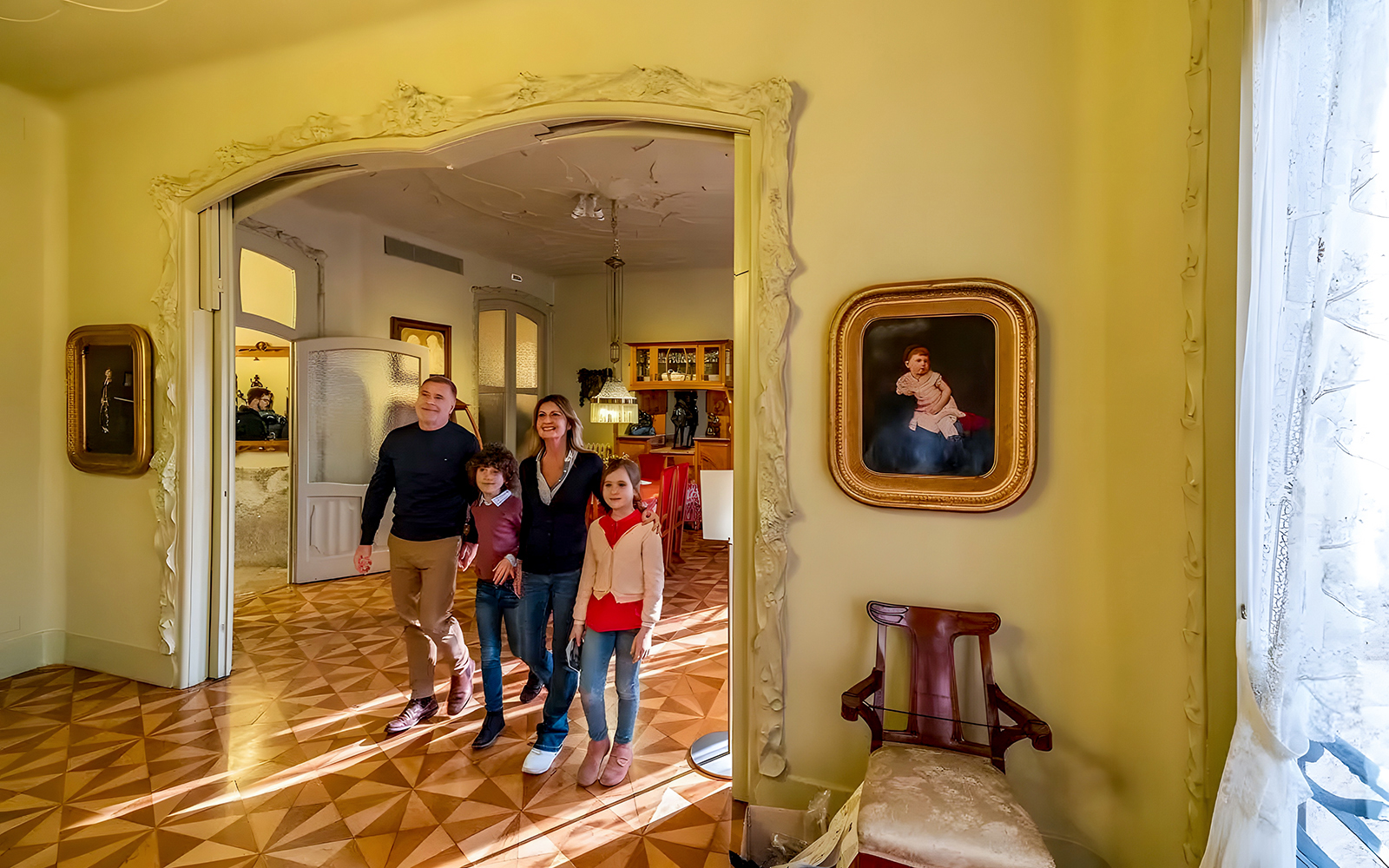 Family exploring interior of La Pedrera during guided tour in Barcelona.