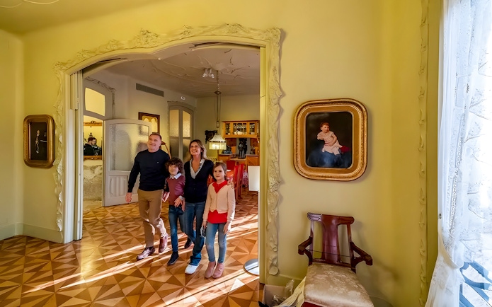 Family exploring interior of La Pedrera during guided tour in Barcelona.