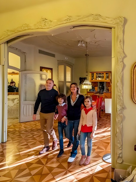 Family exploring interior of La Pedrera during guided tour in Barcelona.