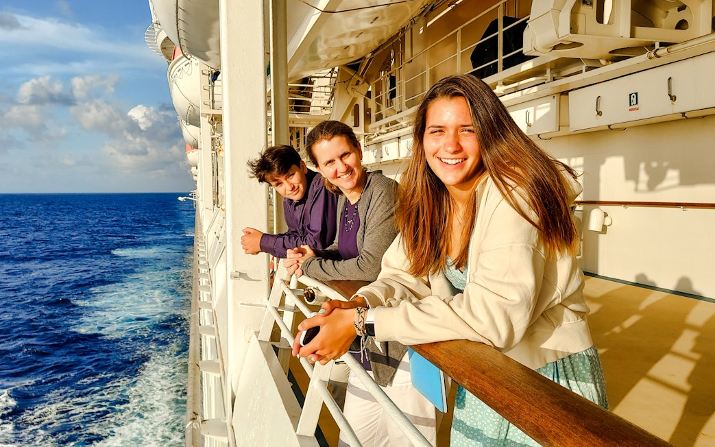 Family enjoying ocean view from cruise ship deck.