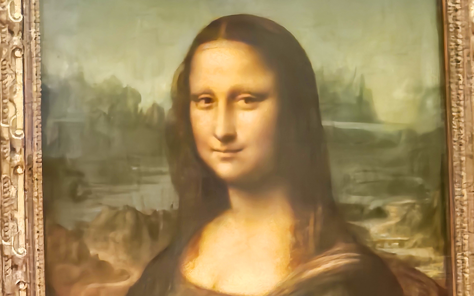 Mona Lisa painting close-up, showcasing her enigmatic smile and eyes at the Louvre Museum, Paris.