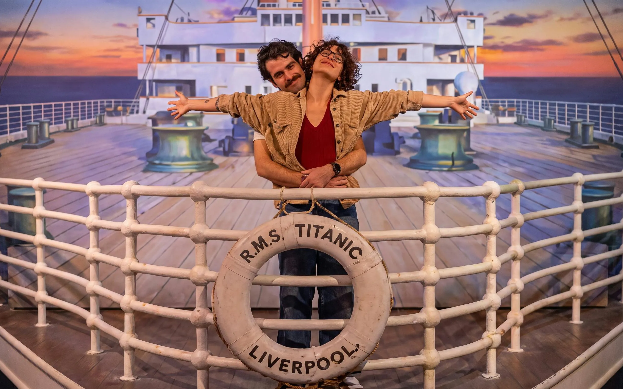 Couple reenacting Titanic scene on ship deck at Titanic exhibit in Utrecht.