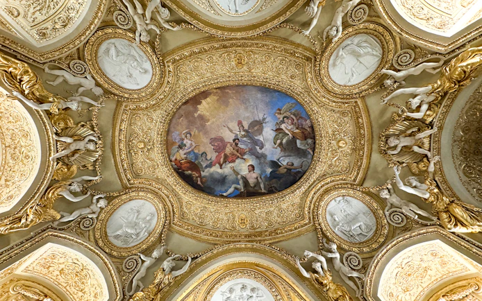 Louvre Museum ceiling artwork with ornate gold details and classical figures.