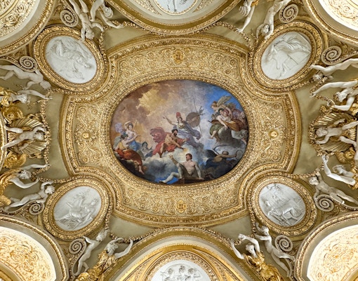 Stunning view of the intricate ceiling artwork at the Louvre Museum in Paris, a unique feature of this popular museum tour