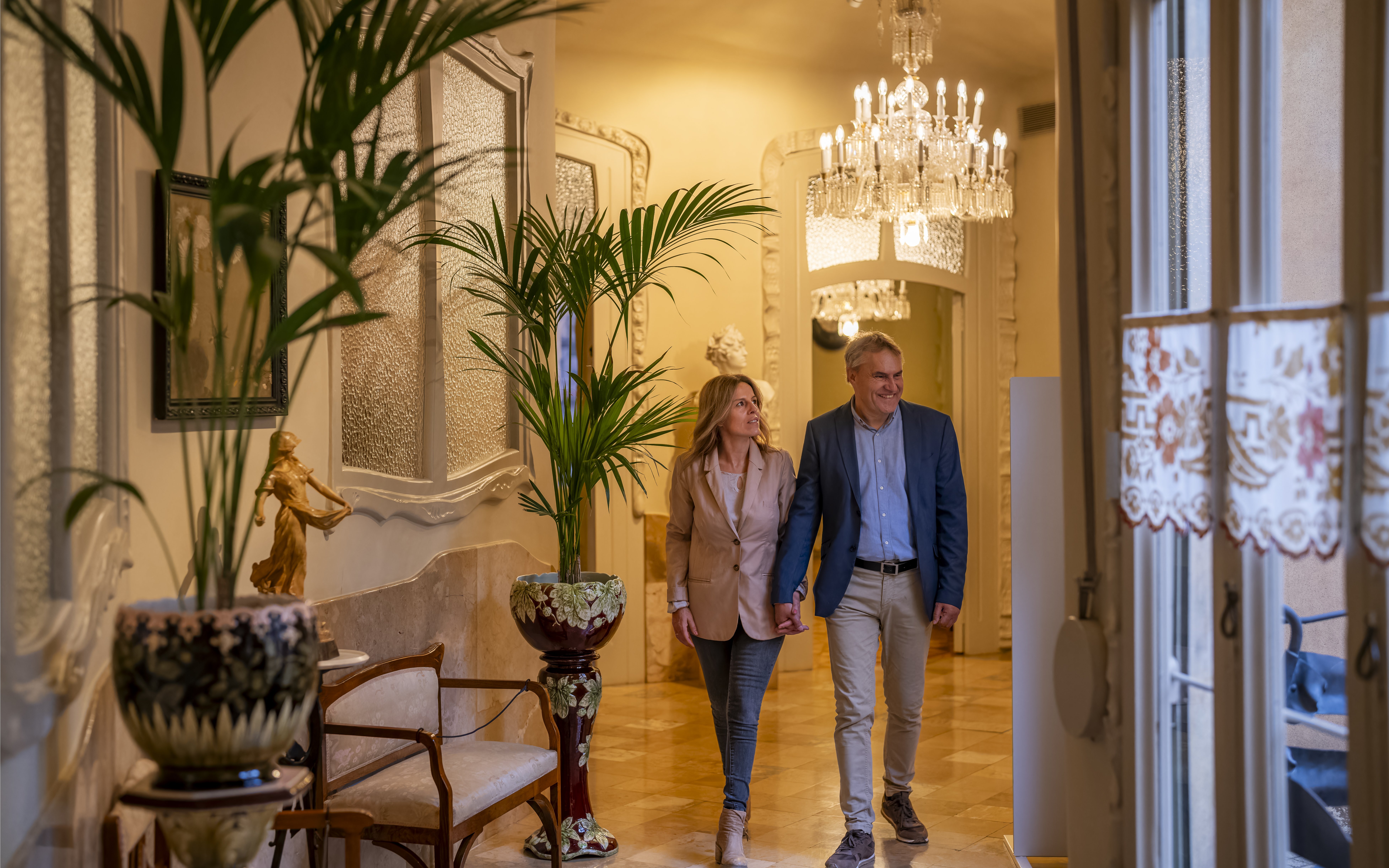 Tourists walking through ornate hallway in Casa Mila, Barcelona.