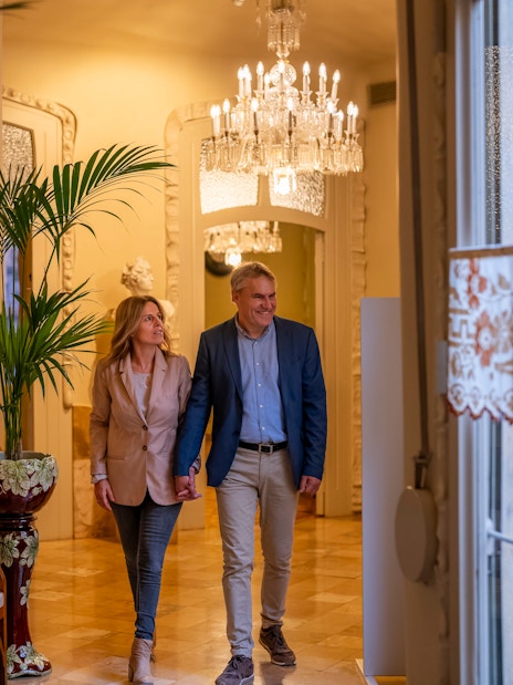 Tourists walking through ornate hallway in Casa Mila, Barcelona.