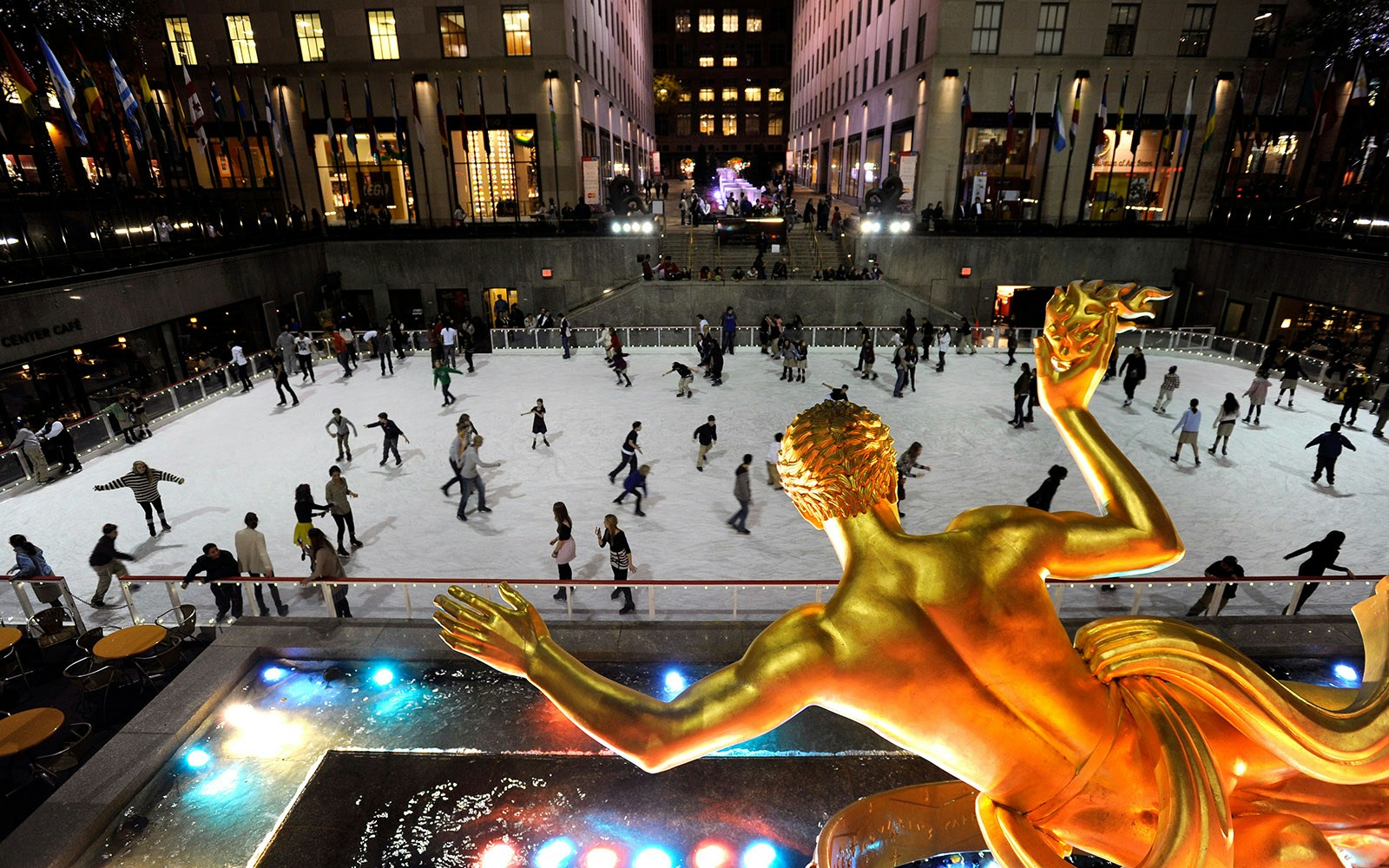 Skaters enjoying The Rink at Rockefeller Center, New York City, with iconic skyscrapers in the background.