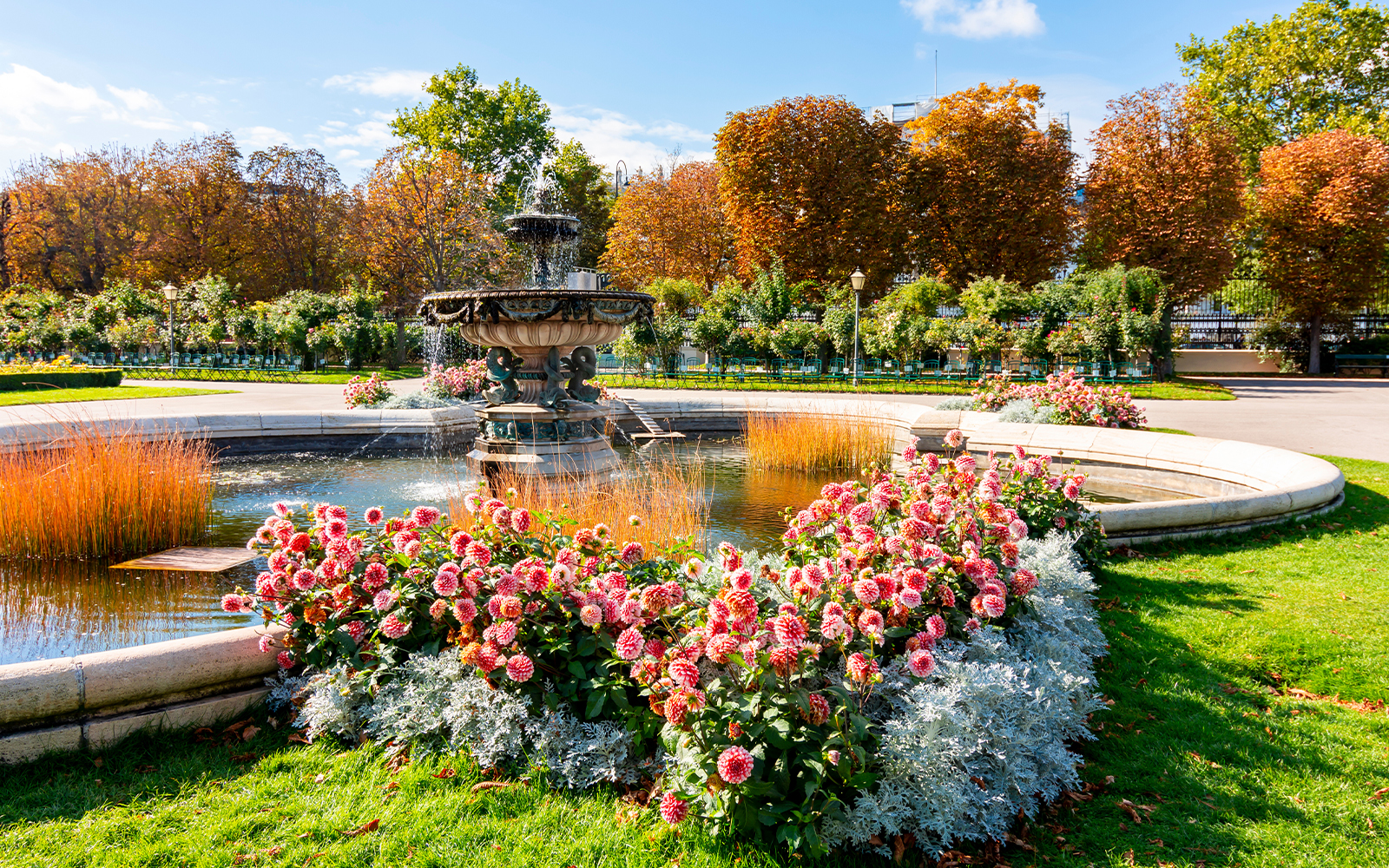 Fountain and flower garden in Vienna near Sisi Museum on a sunny day.